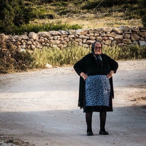 Me in Greece. In the picture is an old but fabulous Greek lady, a "yiayia" (grandma), standing firm in the middle of a village road, with her arms in her side, her posture open, a smile on her face, a grandma headscarf on her head and an apron on. She is me.