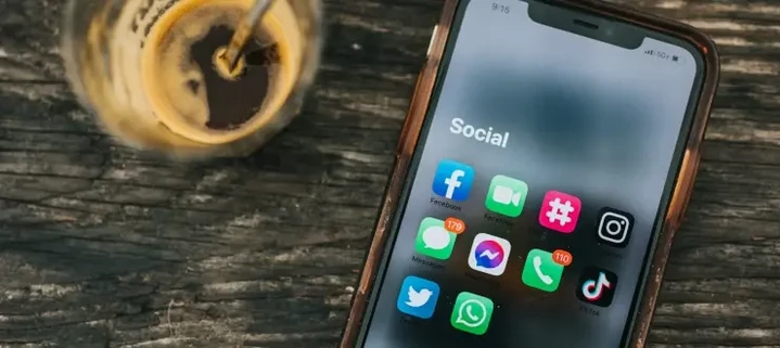 Mobiltelefon auf einem Tisch mit Icons von Social Media Apps angezeigt