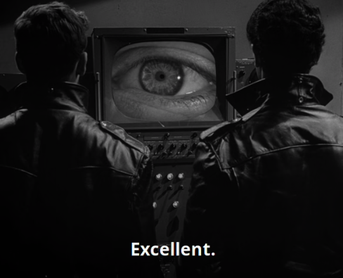 From Twilight Zone Season 5 Episode 18. Two men in leather jackets are facing forward at a television. On the television is a zoomed in eyeball taking up the entire screen. The caption text says "Excellent."