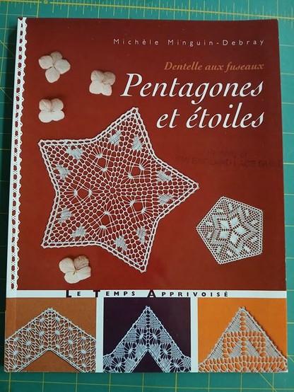 A lace pattern book called Petagones et étoiles, dentelle aux fuseaux. Author is Michele Meguin-Debray. It has a star and a pentagon in white on the main section, and then some triangular edgings in the lower section.