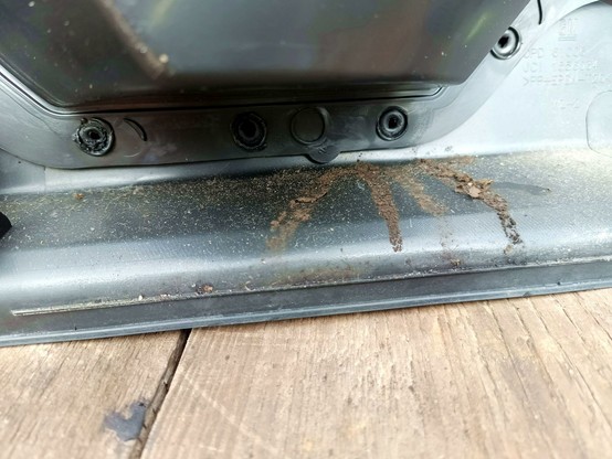 Another close-up of the same panel, There's a four-fingered dirt trace on the black plastic below the inside of a storage compartment.