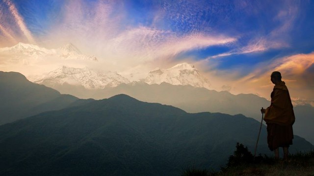 Buddhist monastic looking at a mountain.