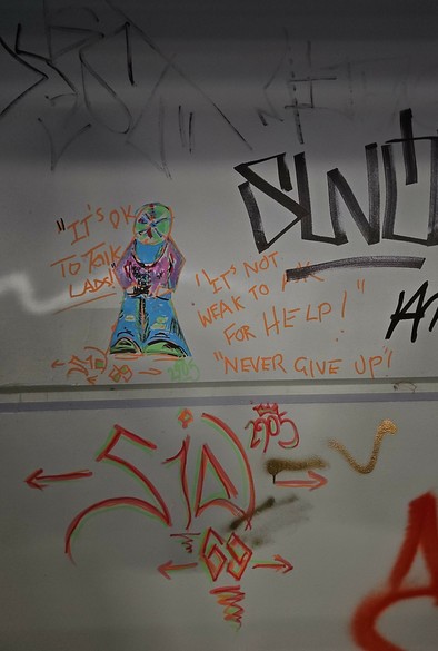 A stylised figure with captions reading "it's ok to talk lads " "it's not weak to ask for help" and "never give up*.