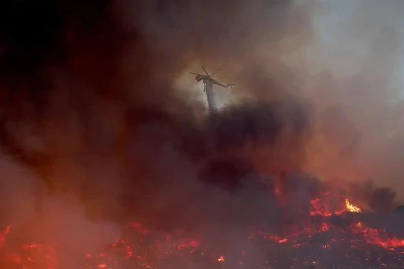 A helicopter drops water on the Canyon fire in Castaic.