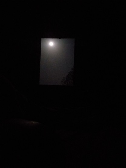 Photo prise de mon lit montrant l'encadrement de la fenêtre avec la lune dans un coin