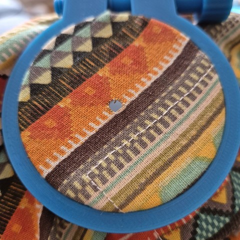 A tiny hole in a colourfull stretched out fabric.