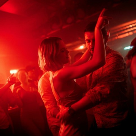 Dance music art: couple dancing in a club with red lighting