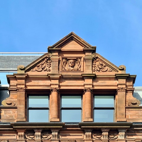 Decorative sculptures on a gable of an 1890s commercial building.