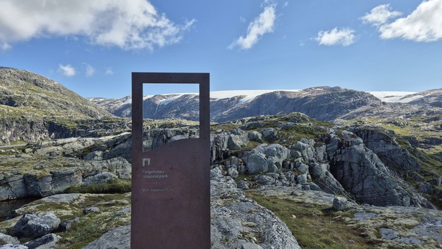 A view at the Folgefonna Glacier. A metal sign at the road side informs about entering the Folgefonna national park.