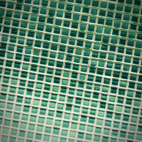 Small green floor tiles fill the frame in a slightly diagonal grid.