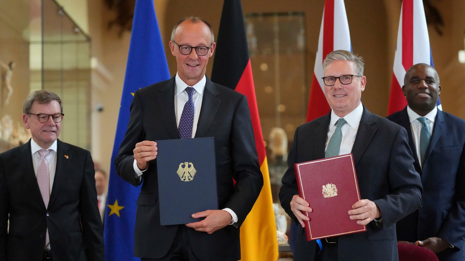 Bundeskanzler Friedrich Merz und Großbritanniens Premier Keir Starmer lächlen in die Kamera. In der Hand halten beide jeweils eine Mappe mit dem so eben unterzeichneten deutsch-britischen Freundschaftsvertrag. Bundeskanzler Friedrich Merz und Großbritanniens Premier Keir Starmer lächlen in die Kamera. In der Hand halten beide jeweils eine Mappe mit dem so eben unterzeichneten deutsch-britischen Freundschaftsvertrag.