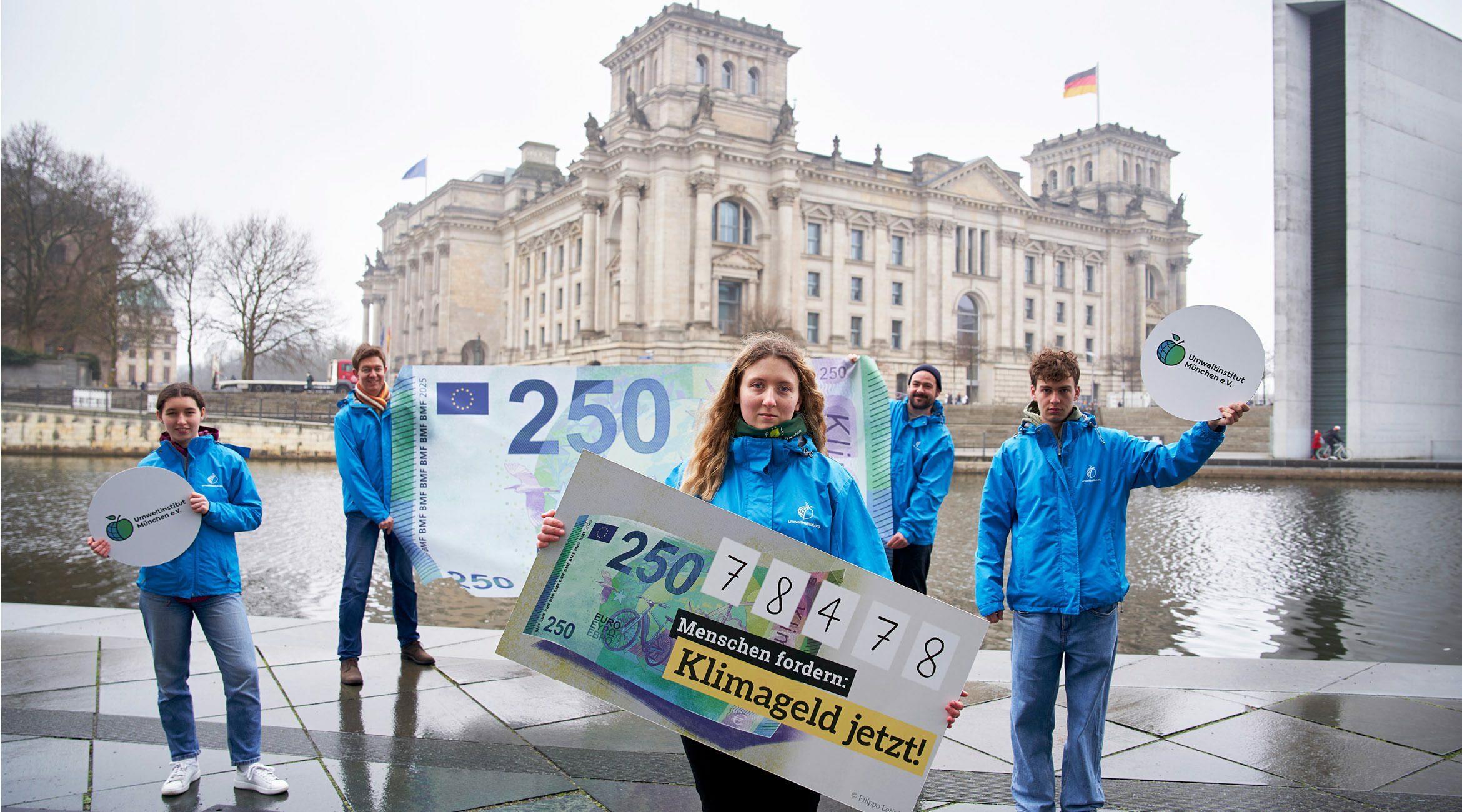 Aktion vor dem Reichstag: Aktivist:innen fordern mit XXL-Klimageldschein die Einführung eines Klimageldes.