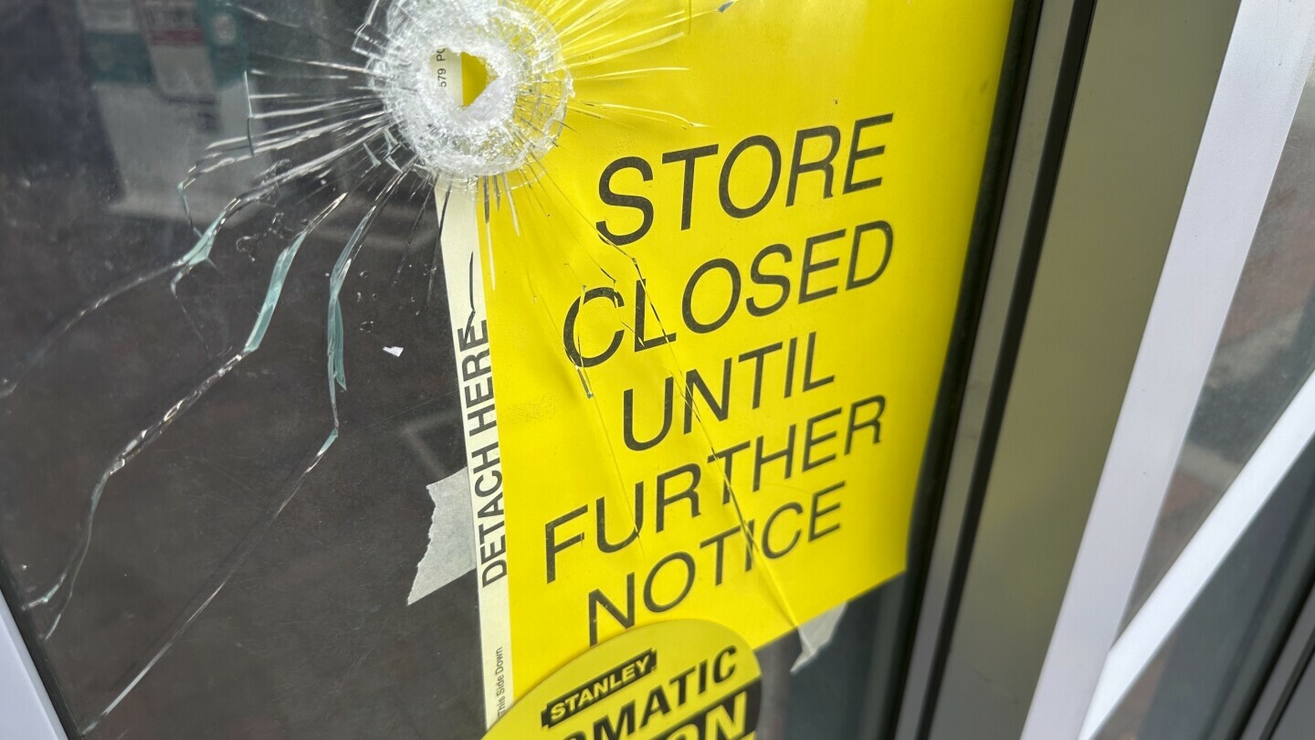 A bullet hole is visible in the door of a CVS pharmacy on Saturday, August 9, 2025, near where police say a man was shooting at the headquarters of the U.S. Centers for Disease Control and Prevention in Atlanta. (AP Photo/Jeff Amy)