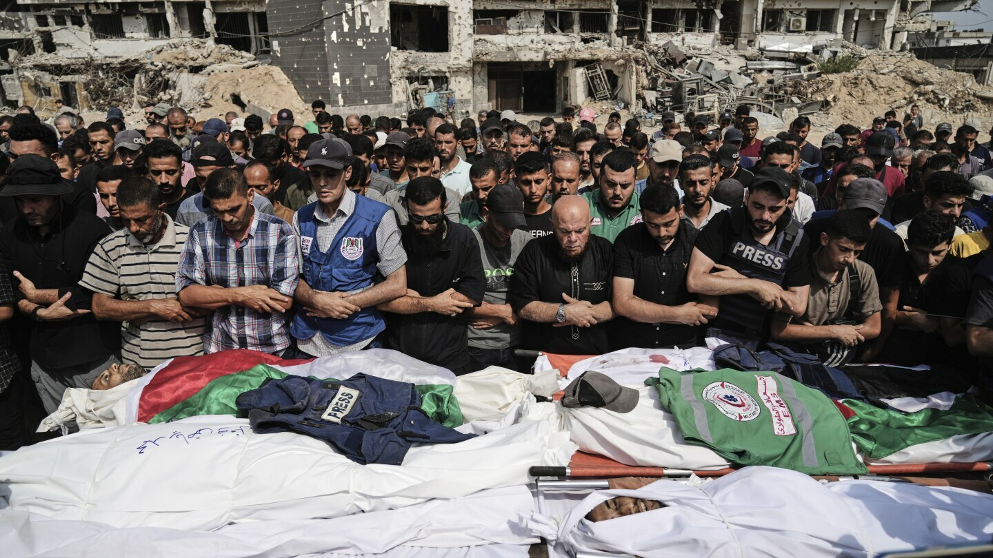 Palestinians pray over the bodies of journalists, including Al Jazeera correspondents Anas al-Sharif and Mohamed Qreiqeh, who were killed in an Israeli airstrike, during their funeral outside Gaza City's Shifa hospital complex, Monday, Aug. 11, 2025. (AP Photo/Jehad Alshrafi)