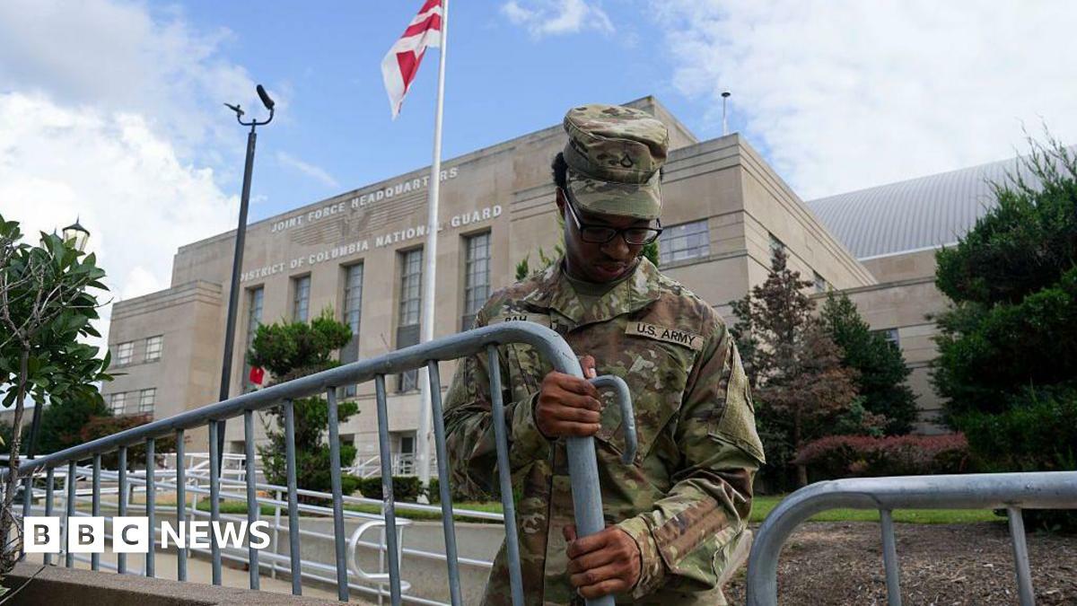 A soldier erecting a barricade outside a government building
