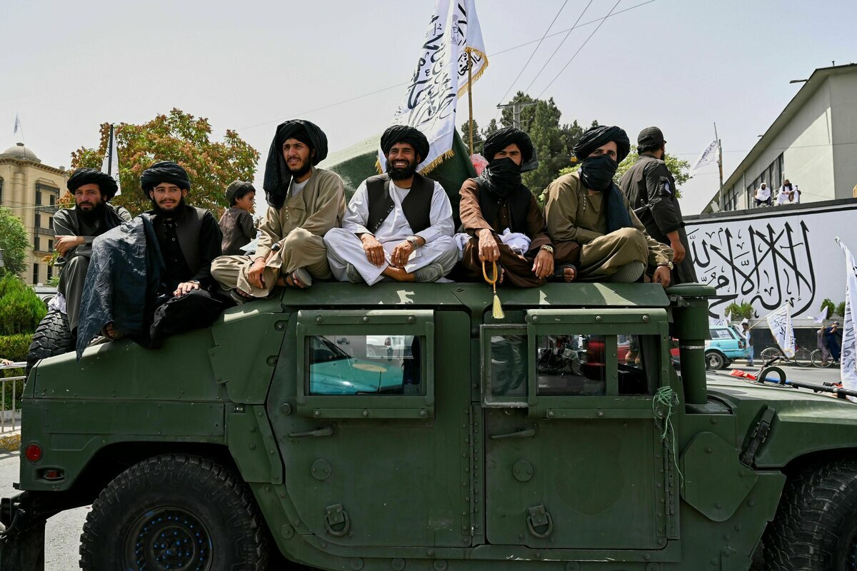 Taliban-Kämpfer fahren während Feierlichkeiten auf dem Dach eines Humvees mit.