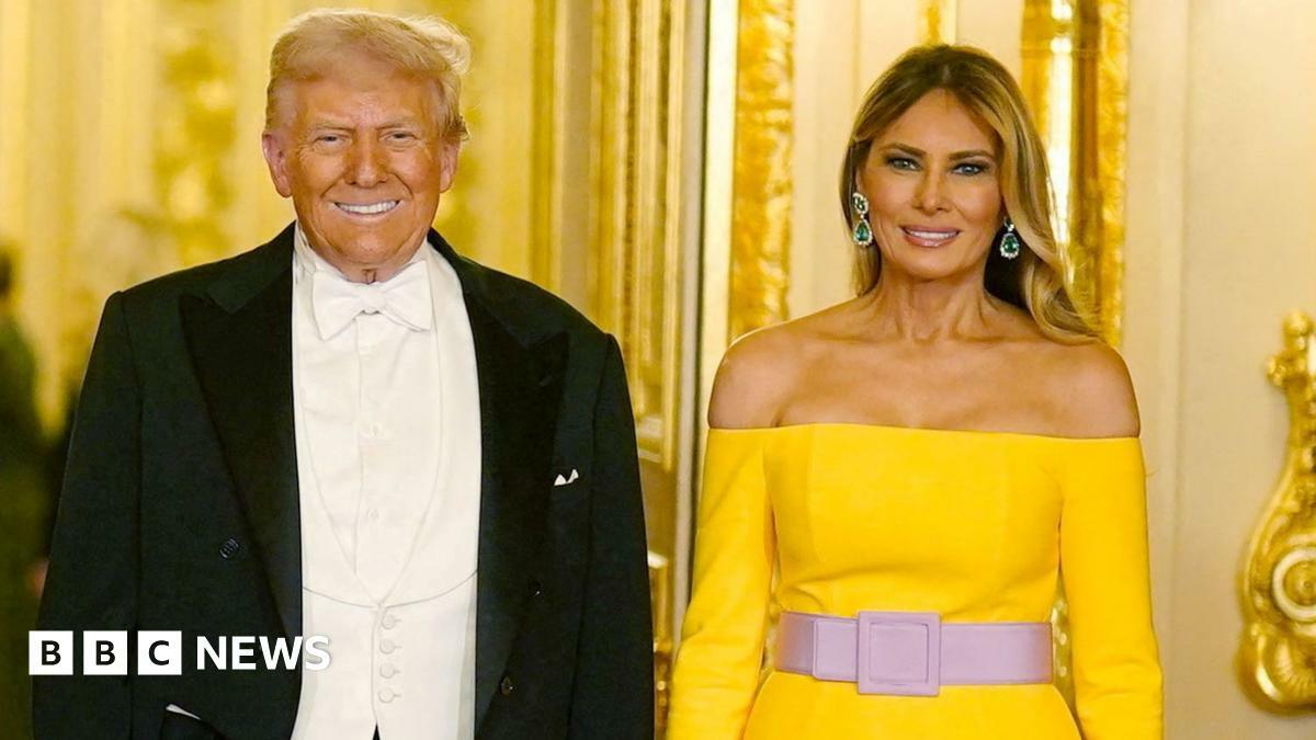 Donald and Melania Trump pose for a picture before the banquet at Windsor Castle, he wears a suit and tux and she wears a yellow dress.