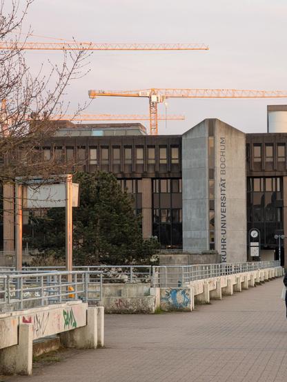 Ruhr University Bochum campus seen from near the U35 station. Two large tower cranes can be seen poking up from behind buildings in the foreground