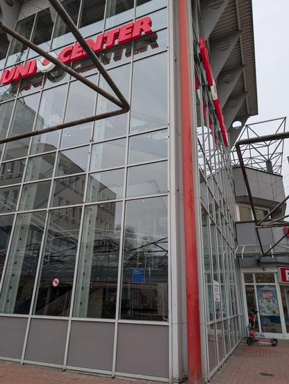 Glass building facade with steel eye loops attached in five rows across the face
