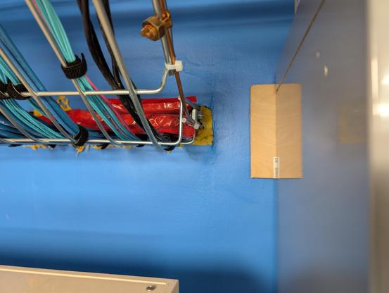 Cable tray of cat5 and fiber with red firestop pillows and yellow caulk