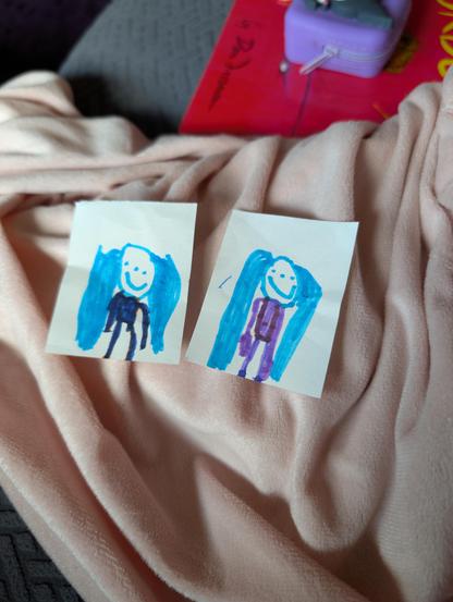 Two small marker doodles of a humanoid figure with long blue hair