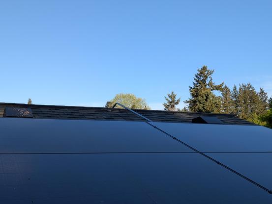 Rooftop solar panels waiting for the sun to rise above the hill so they can chow down