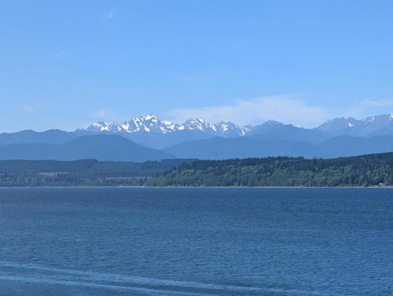 Snow capped Olympic mountains seen from across the hood canal on a beautiful clear day