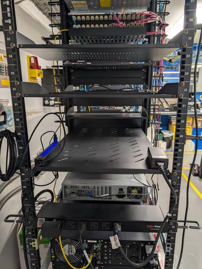 Back view of a rack shelf with a usb hub on it