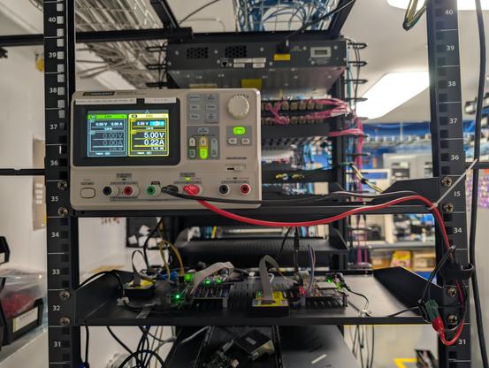 Front side of the setup showing a Siglent power supply on the shelf above powering one of the boards