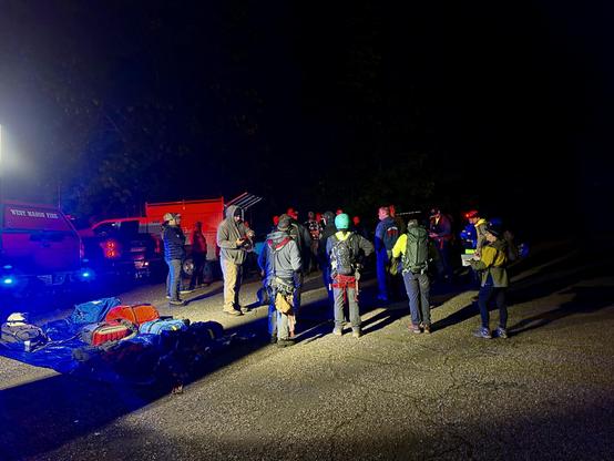 Night view of fire and technical rescue personnel staging on a dirt road