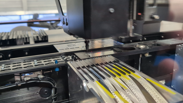 Pick and place machine grabbing SMT components off tape and populating them on a PCB