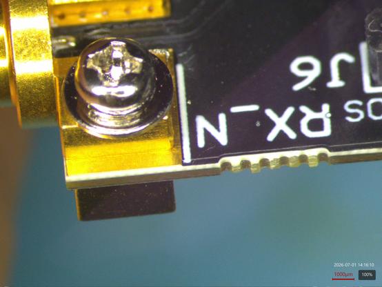Closeup microscope view of the edge of the SFP28 test fixture showing the top dielectric layer of the PCB is bright white meaning it's a fancy low loss dielectric