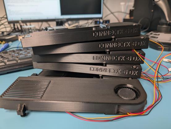 Stack of 3d printed fan shrouds marked "ConnectX 6 DX"
