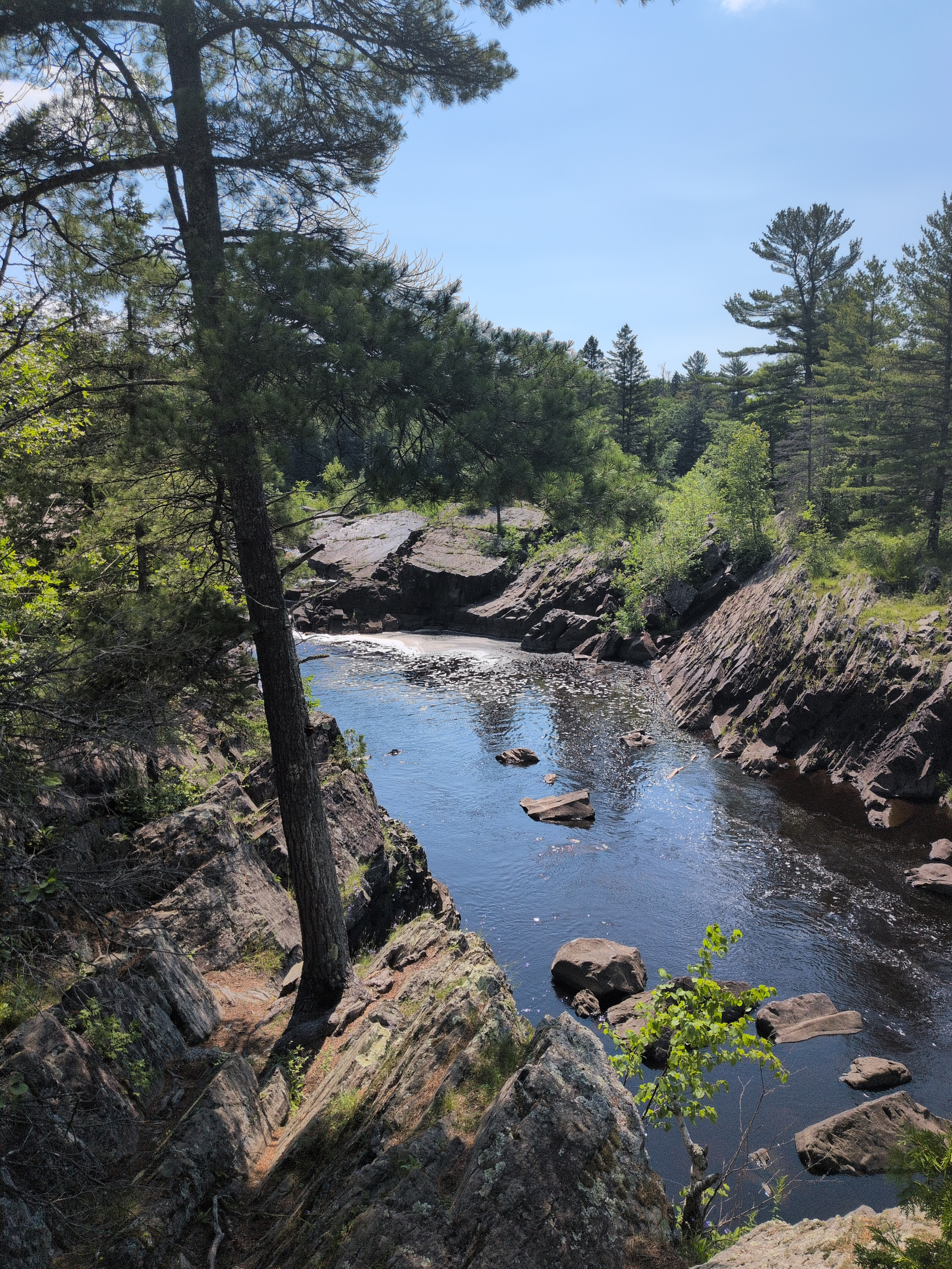 The Saint Louis River flowing through slanted rocks forged by the violent and  beautiful acts of nature and time.