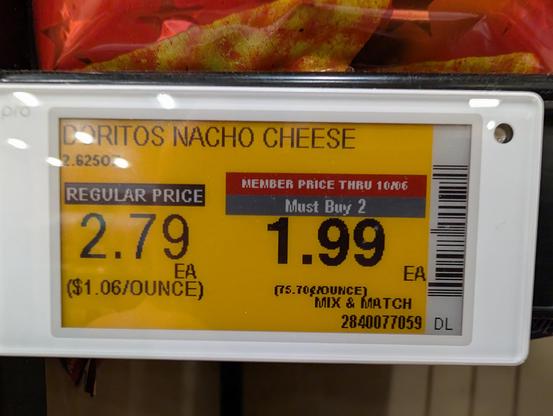 Black/white/red/yellow eink price tag label in a store with a gray "must buy 2" box above a discounted price