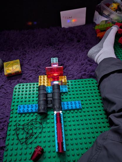 LED maglite shining through a pair of cheap binoculars, a diffraction grating, and a clear red plastic toy and projecting a spectrum of said toy on a sheet of paper