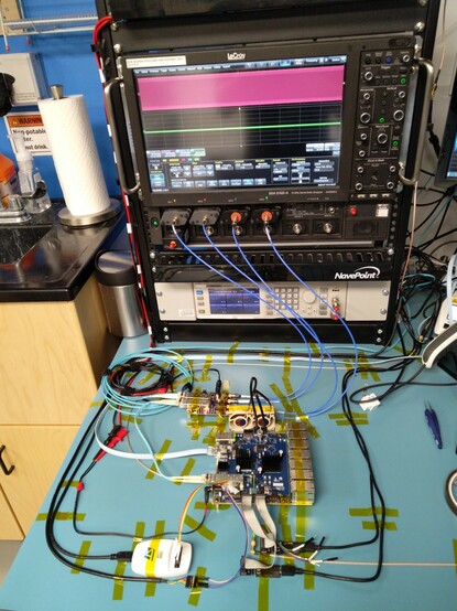 Photo of lab bench with switch board and test fixture cabled to oscilloscope