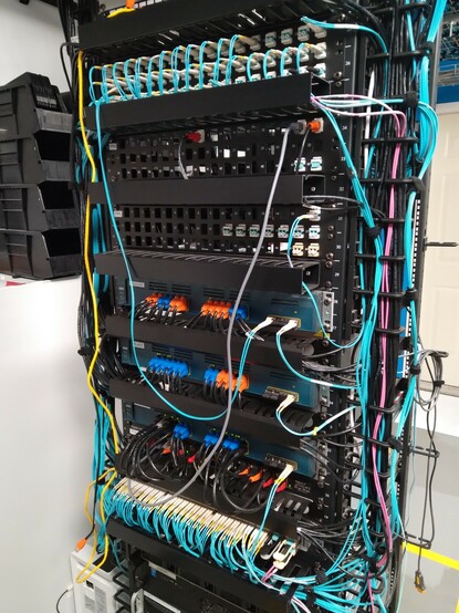 Switch rack with a temporary fiber cable coming off a patch panel and into the front of a switch