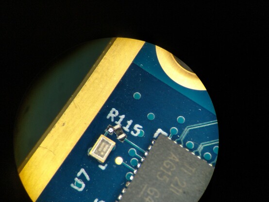 Corner of an Ethernet PHY showing a clock oscillator with a series terminator that's floating off at an angle, only connected to one pad