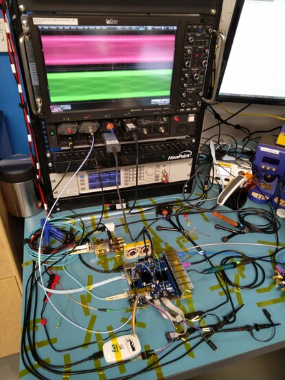 Long shot of very crowded lab bench covered in cables and probes