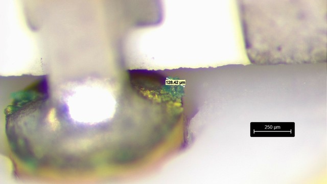 Closeup of green crystal measuring 128um across on a SMA center pin