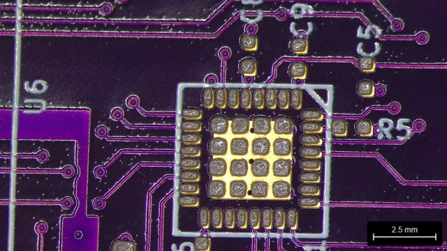 QFN footprint with solder paste on it. The paste is maybe 25-50 μm northwest of perfectly centered.