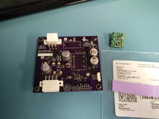 Assembled PCB with a thermal pad sitting next to it