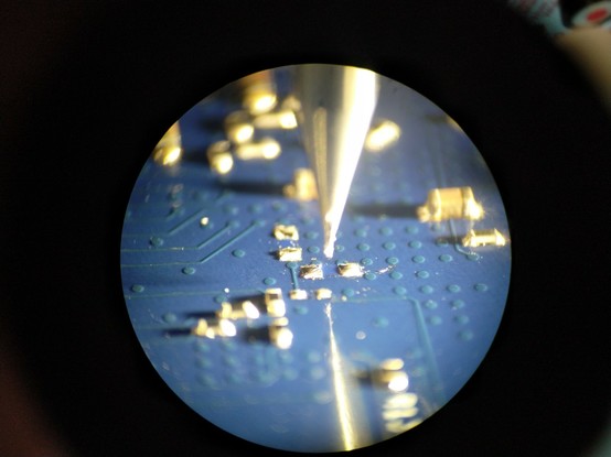 View through an angled microscope showing the area of planned rework with a tiny endmill hovering over it