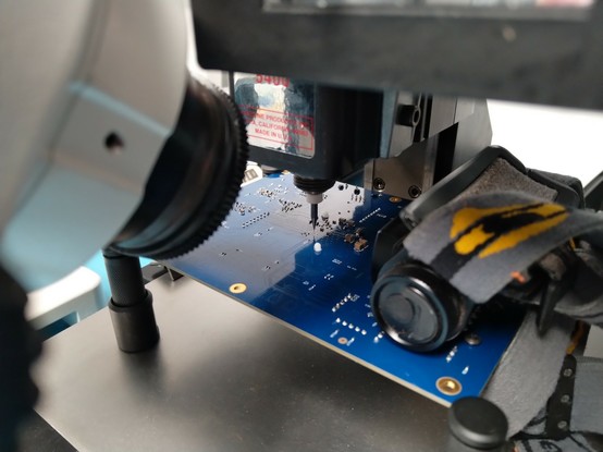 Long shot of rework setup showing board on mill table with microscope aimed at it