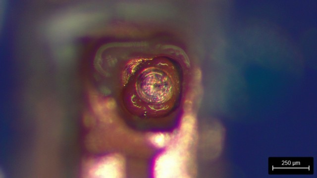 Closeup of the rework site showing the back side of the target BGA pad with exposed copper in the middle
