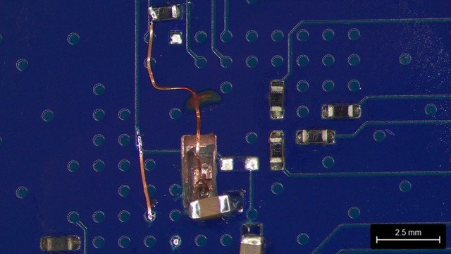 Finished rework showing a wire coming out of the hole at the bottom of the board, plus another surface track reconnecting the cut remote-sense line