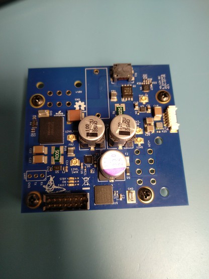 Blue PCB densely populated with SMT components. Obviously non reflowed solder paste can be seen on some pads. Through hole component footprints are bare.