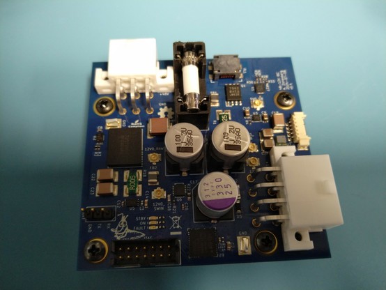 Small blue PCB densely packed with power components. A 6 pin Molex power input is at the northwest corner and an 8 pin output at the southeast.