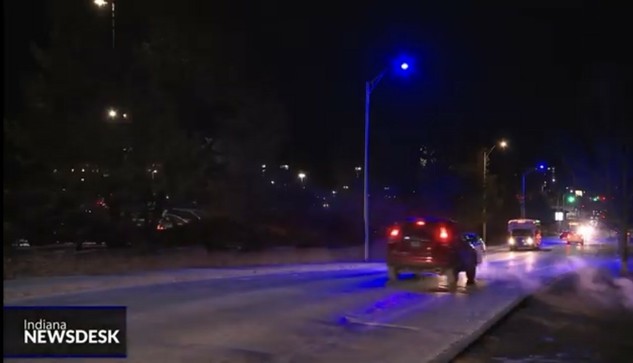 A screencap of a TV report from the USA showing purple street lights. 